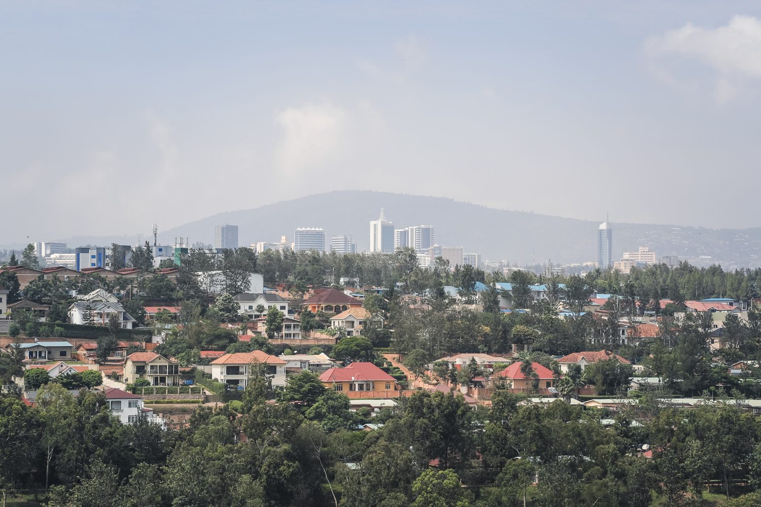 Aerial view of Kigali skyline at dusk with rolling hills in the background